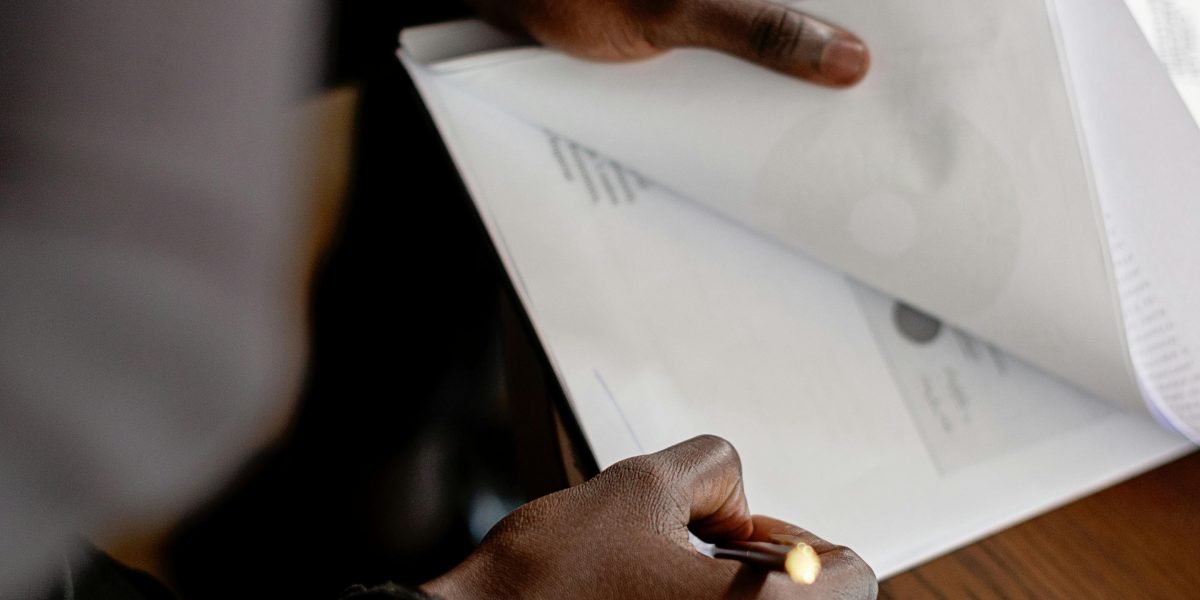 A person thoughtfully reviewing various financial documents, symbolizing the burden of medical debt.