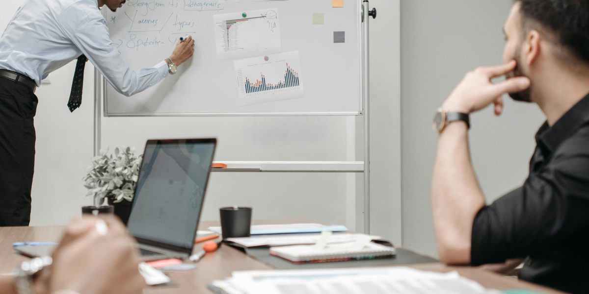 A medical team actively collaborating, using a whiteboard to strategize solutions for integrating new technologies.