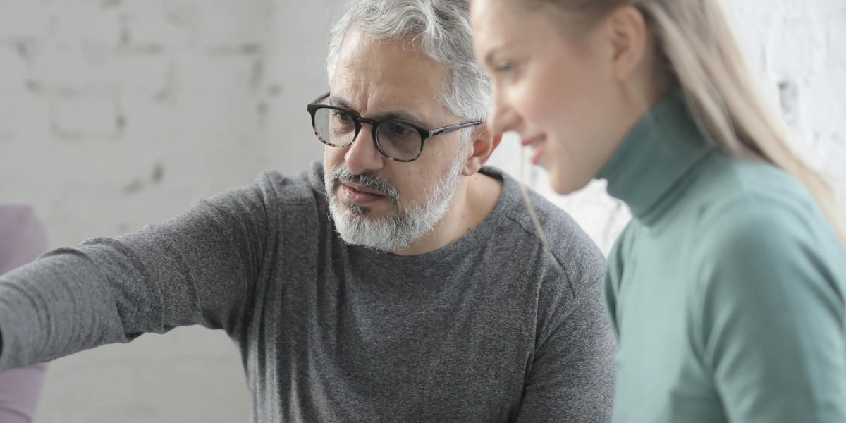 An experienced clinician guides a colleague through a new system or process, fostering trust and knowledge sharing.