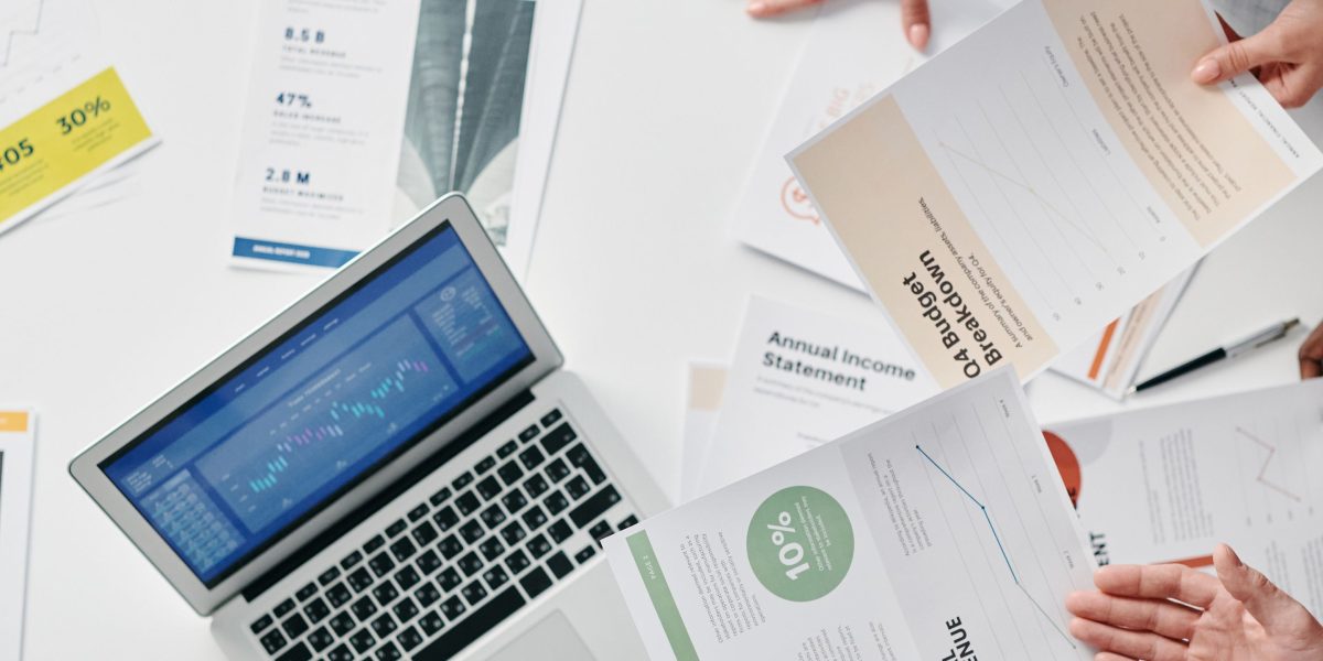 A team of professionals reviewing charts and reports, symbolizing the analysis of financial data and program impact.
