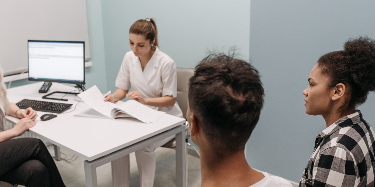 A diverse medical team from different specialties discusses a patient case, emphasizing clear communication.