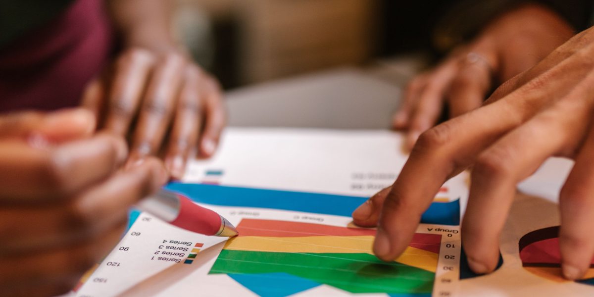 A business team reviews financial reports and projections, focusing on the economic impact of new clinical technologies and potential ROI.