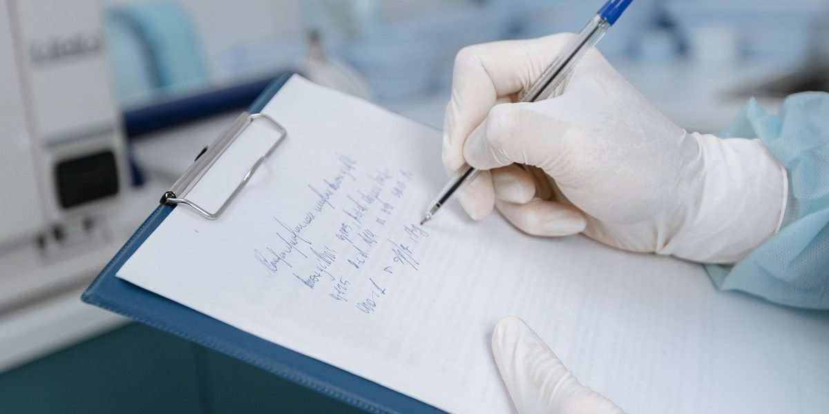 A medical professional carefully documents patient information in a clinical setting.