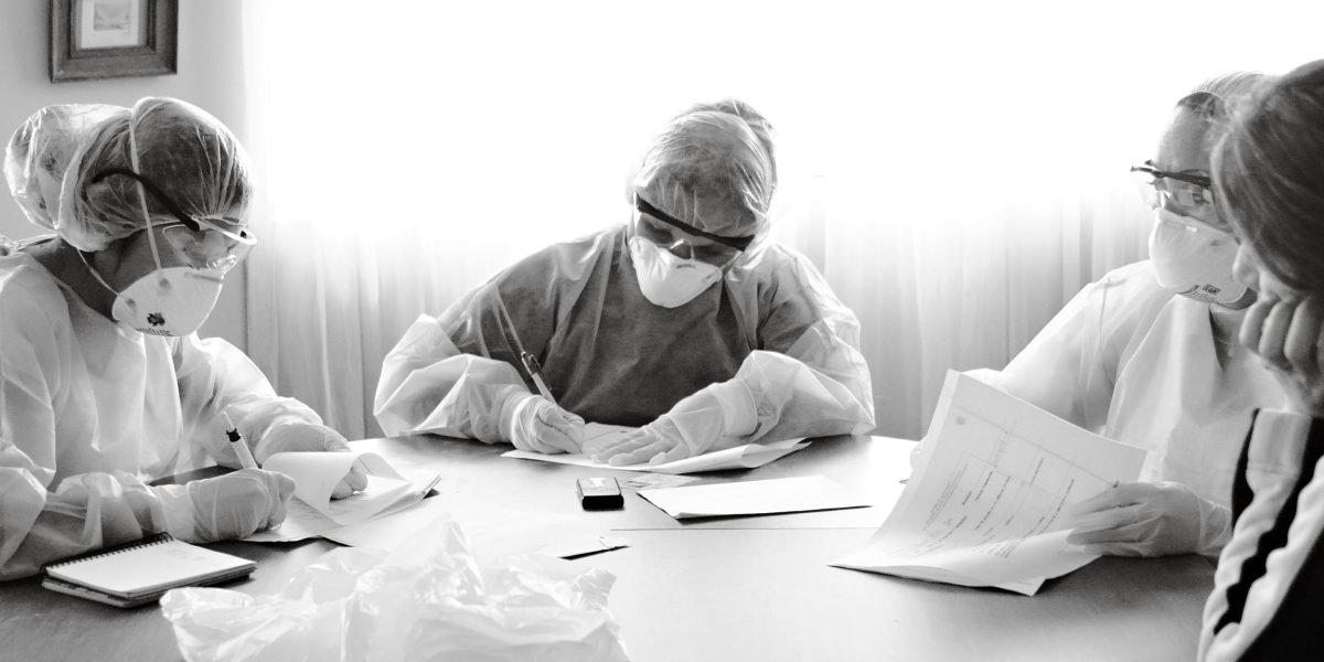 A diverse team of healthcare professionals collaborating on a strategic plan in a modern office setting.