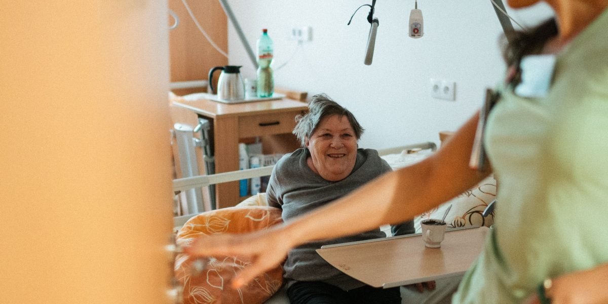 A healthcare professional showing compassion while assisting an elderly patient in a comfortable care setting.