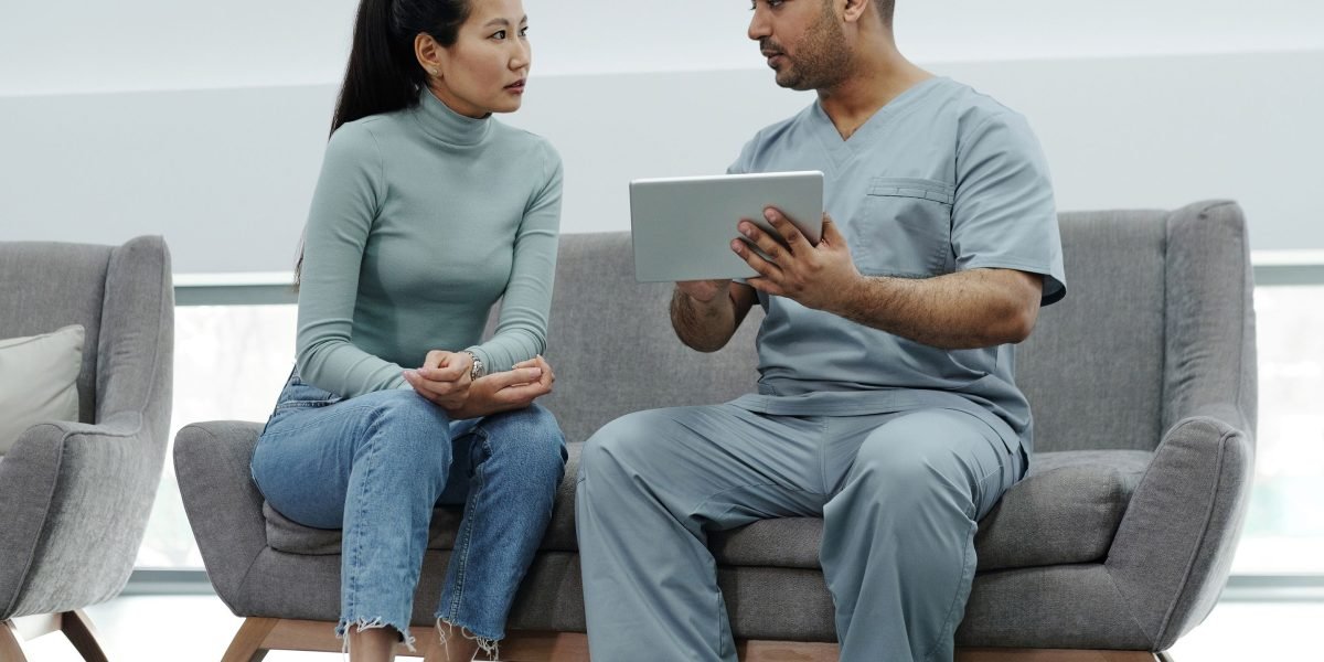 A doctor and patient engaging in a thoughtful discussion about health concerns in a clinical setting.