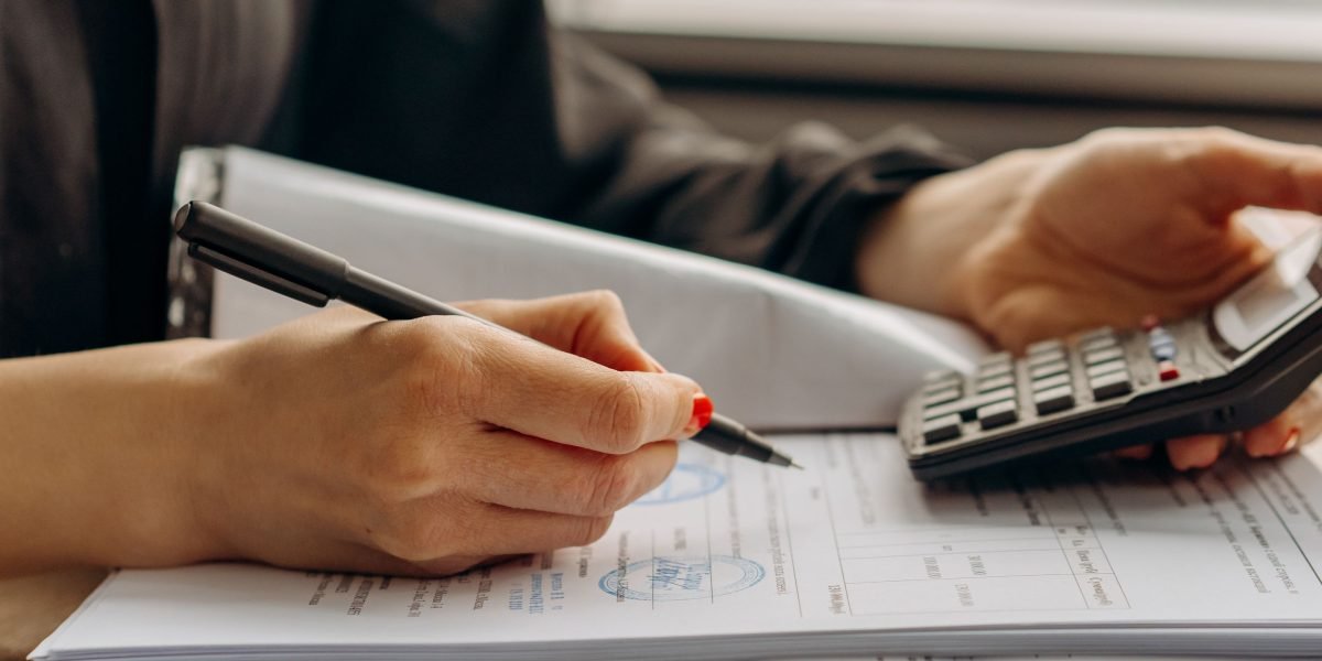 A person carefully reviews documents related to financial aid, reflecting the consideration of costs for second-degree nursing programs.